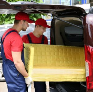 Günstig umziehen in Singen Günstig umziehen in Singen: Umzugshelfer laden ein gelbes Sofa in einen Transporter