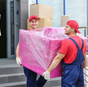 Umzug in Singen Zwei Umzugshelfer tragen ein in Folie gepacktes Möbelstück – Umzug in Singen