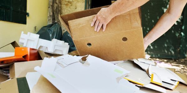 Hände sortieren Papiere und Unterlagen in einem Karton – Entrümpelung in Singen