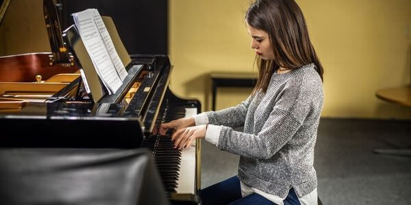 Klaviertransport Singen: Frau spielt an einem Klavier
