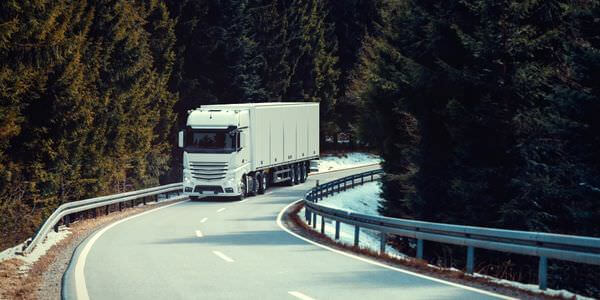 Klaviertransport Singen: Lkw fährt auf einer kurvigen Straße durch den Wald
