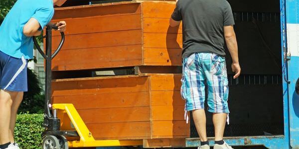 Möbellift Singen: Zwei Helfer tragen einen Holzschrank aus einem Lkw
